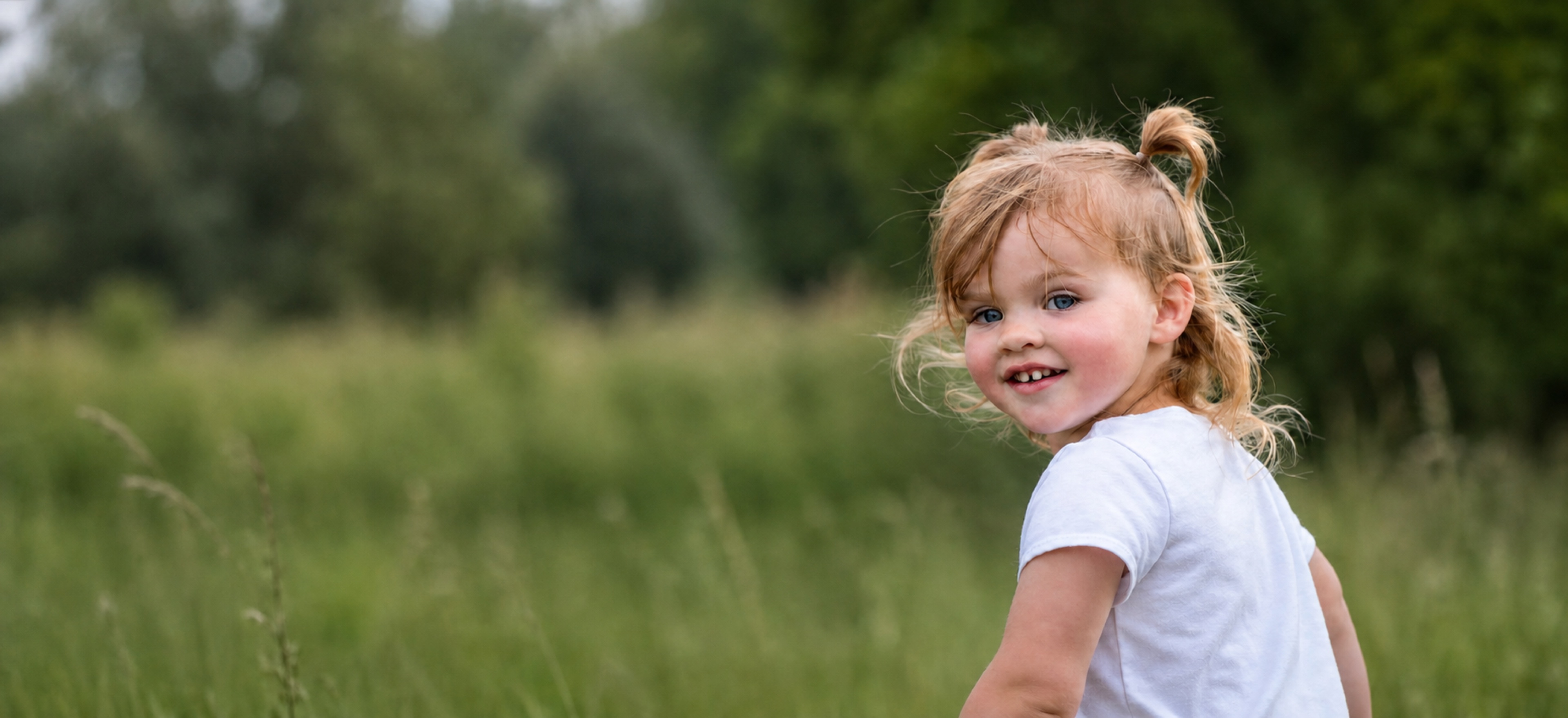 A joyful young girl looking back in a grassy field